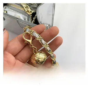 Detail of PU leather shoulder strap with gold metal sphere and dual-tone chain link