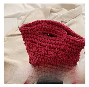 Detail shot of magenta knitted shoulder bag showing thick textured rope weave pattern