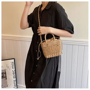 Straw bucket bag with drawstring pouch shown as a crossbody on a stylish model