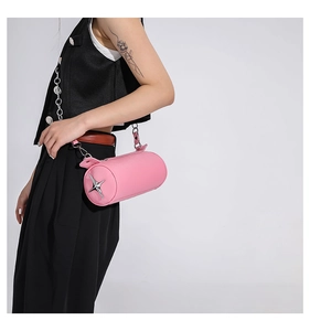 Detail of pink cylinder shoulder bag featuring lychee grain leather and silver star logo