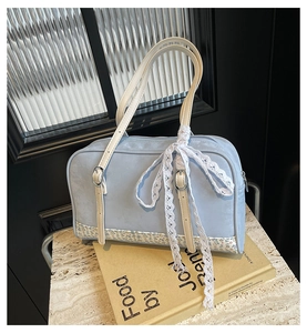 Detail of light blue PU leather handbag featuring floral patchwork and lace bow decoration