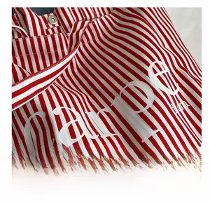 Detailed close-up of red and white striped canvas tote bag with metal button and carpe text