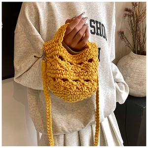Close-up of ginger yellow handmade knit crochet bag with Halloween pumpkin face detail