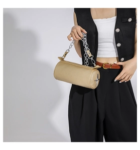 Detail of champagne gold cylindrical handbag with silver chain and star decoration
