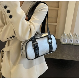 Close-up of a trendy silver PU leather rectangular handbag with black straps shown on a model