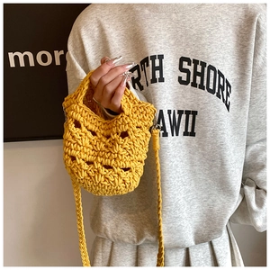 Detail of mango yellow hand-woven mini bag with hollow diamond pattern and silver clasp