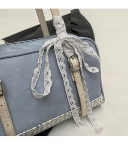 Close-up of blue PU leather bag with white lace bow decoration and floral trim detail