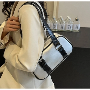 Silver metallic PU shoulder bag with black leather strap worn by model in white suit