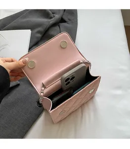 Detail view showing internal storage for phone and card case in pink quilted PU bag