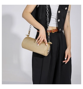 Fashionable golden cylindrical handbag with silver star accessory and chain strap