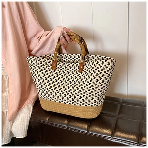 Detail of woven tote bag with bamboo handles and chic black and white checkered texture