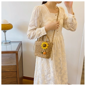 Detail of straw handbag with yellow sunflower and pumpkin charm decoration