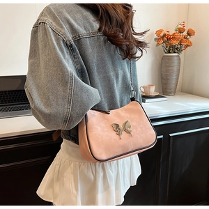 Vue détaillée du sac sous le bras en faux suède rose avec boucle papillon argentée