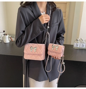 Pink quilted crossbody bag set with silver bow detail and chain strap on a model