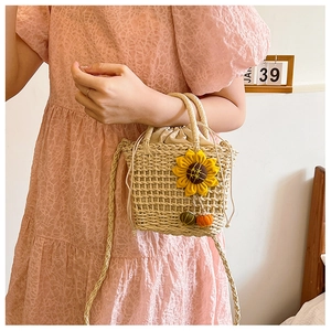 Close-up of handmade straw bucket bag with sunflower decor and drawstring inner pocket