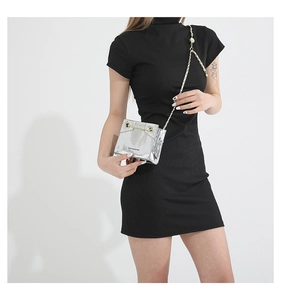 Detail of silver laser PU leather crossbody bag with golden chain strap and round buckle