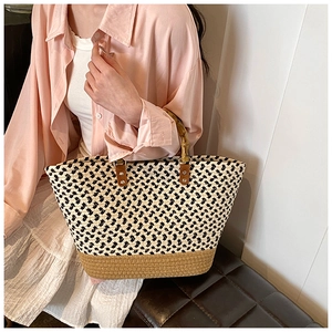 Detailed view of woven tote bag with bamboo handles and contrasting texture on model