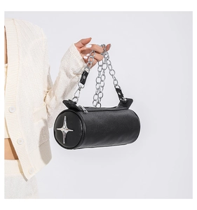 Detail of black pebbled PU leather cylinder bag with silver star badge and chain strap