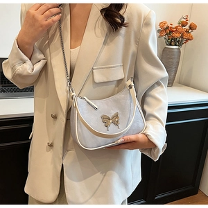 Détail du sac en cuir PU bleu clair avec boucle papillon décorative et bandoulière chaîne