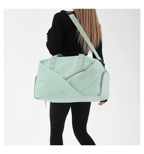 Detail view of mint green waterproof travel bag showing texture and adjustable shoulder strap