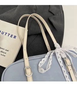 Close-up of light blue PU leather shoulder bag featuring a white lace bow and adjustable strap