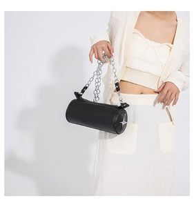 Detail of black cylindrical handbag with silver metal chain strap and star emblem