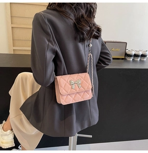 Detail showing pink quilted PU leather shoulder bag with a silver bow and chain strap