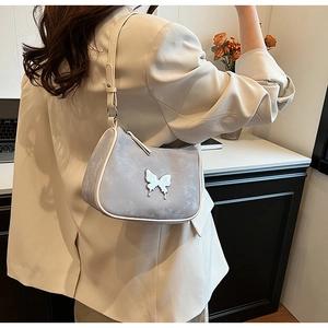 Détail du sac demi-lune en cuir PU gris avec papillon argenté et liseré crème