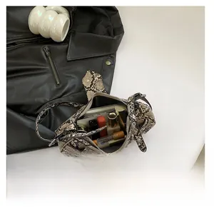Close-up of snake pattern shoulder bag showing interior storage for phone and lipstick