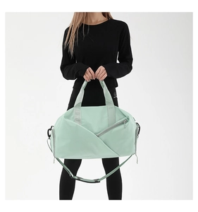 Detail of mint green nylon gym bag featuring functional diagonal zipper and side compartment