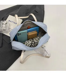 Top view of spacious interior of light blue PU leather tote bag with daily essentials