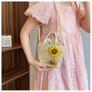 Close-up of woven straw bucket bag with sunflower decor and drawstring lining detail