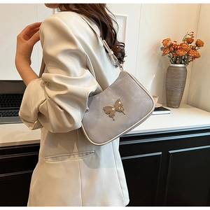Détail du sac bandoulière en similicuir lilas avec un fermoir papillon doré élégant