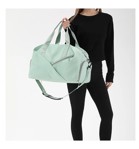 Detail of mint green waterproof nylon gym bag featuring wide handles and side pockets