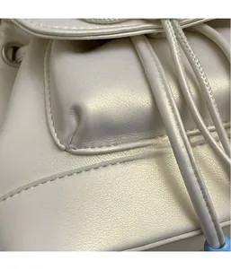 Detail of pearl white PU leather fabric with precise stitching and drawstring design