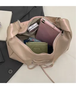 Spacious interior of beige faux leather crossbody bag showing high capacity for tablets