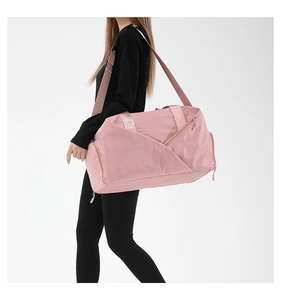 Detail showing high-density nylon pink travel bag with adjustable strap and side shoe pocket