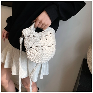 Detail of hand-woven crochet bag in cream white with intricate knitted texture
