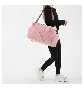 Lifestyle shot of pink water-resistant fitness bag with multiple zipper compartments