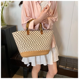 Detail of hand-woven tote bag featuring retro bamboo handles and textured diamond pattern