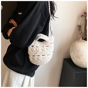 Detail of white hand-knitted tote bag with geometric hollow patterns and sturdy handles