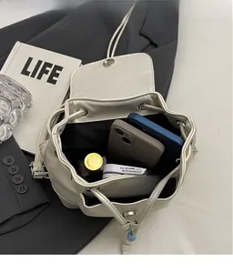 Top view of cream PU leather drawstring backpack showing interior storage capacity for essentials