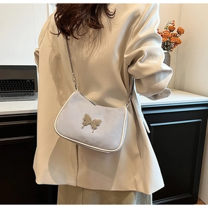 Détail du sac bandoulière en similicuir bleu clair avec breloque papillon et bandoulière