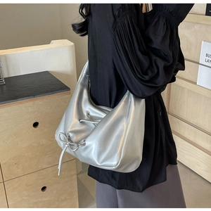 Detailed side view of silver PU leather hobo bag with drawstring bow and metal zipper