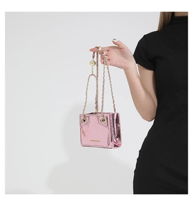 Close-up of a mini pink metallic PU leather crossbody bag with polished chain strap detail