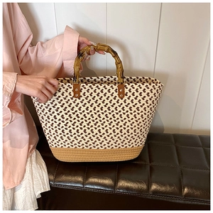 Detailed close-up of the woven texture and bamboo handles on this chic tote bag
