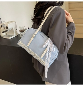 Detail of light blue PU handbag featuring vintage floral patchwork and white lace bow