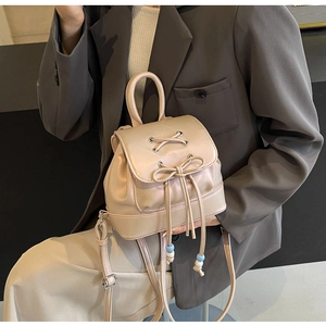 Close-up of champagne gold mini backpack with stylish lace-up bow and beaded drawstring