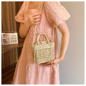 Detailed view of handmade straw bucket bag with mesh weave and drawstring pouch