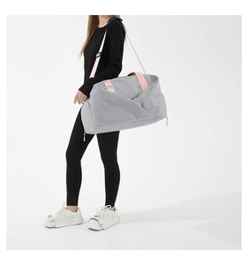 Detail of grey waterproof nylon travel bag with pink straps and zippered shoe compartment